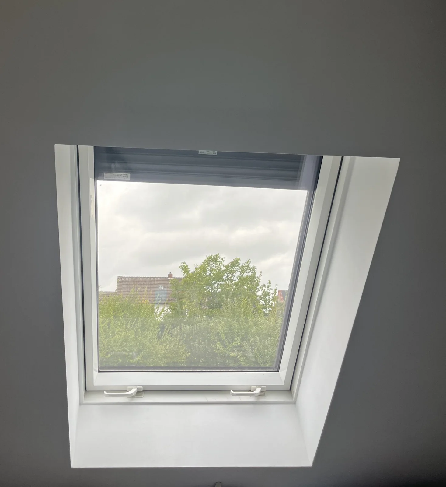 Dachfenster mit weißer Innenverkleidung und außenliegendem Sonnenschutz